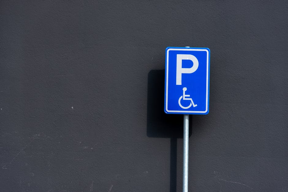A close-up view of a parking space marked with a large white arrow painted on dark asphalt, indicating vehicle movement direction within the designated parking area. The paint appears fresh with disti
